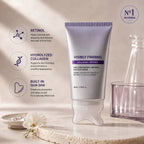 Purple Haenyo Visibly Firming gua sha cream tube standing on a stone tray beside a white flower, with labelled callouts for retinol, hydrolyzed collagen and the built-in gua sha applicator.